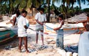 Ryb��i na pl�i p�eb�raj� �lovek. Arugam Bay. Sr� Lanka.