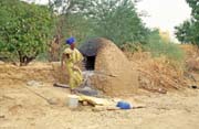 Pe�en� chleba (tedy sp�e chlebov�ch placek). Vesnice Niafunk�. Mali.